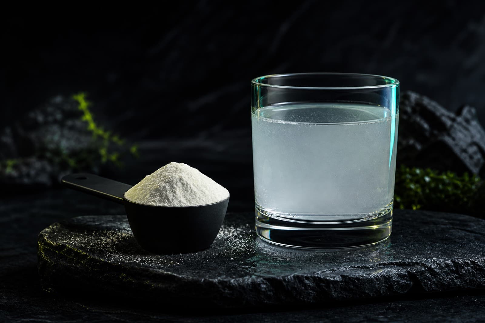 Collagen peptide powder in a scoop and a glass of dissolved collagen drink