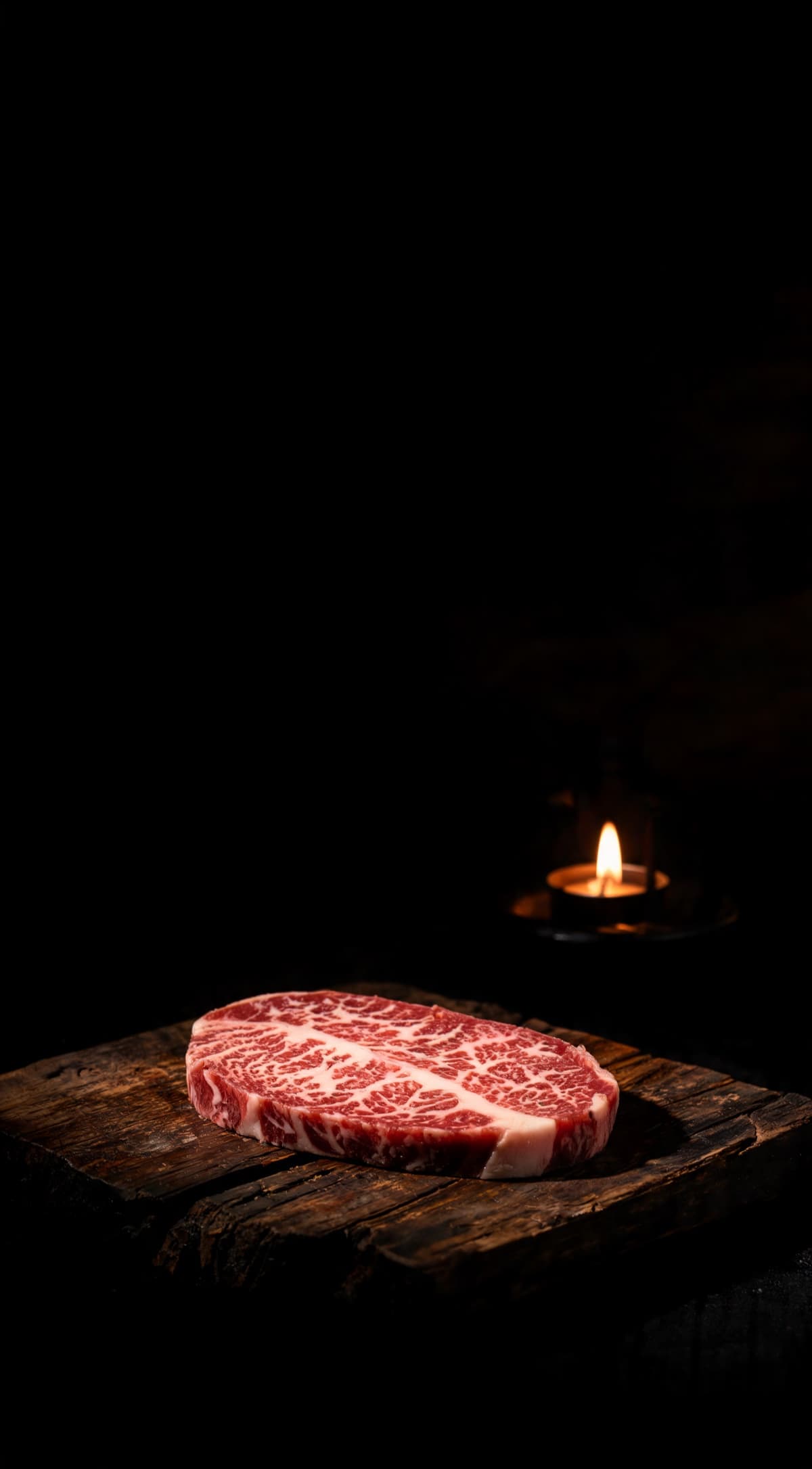 A5 Wagyu — The marbled beef, lit by a single flame in a dark kitchen