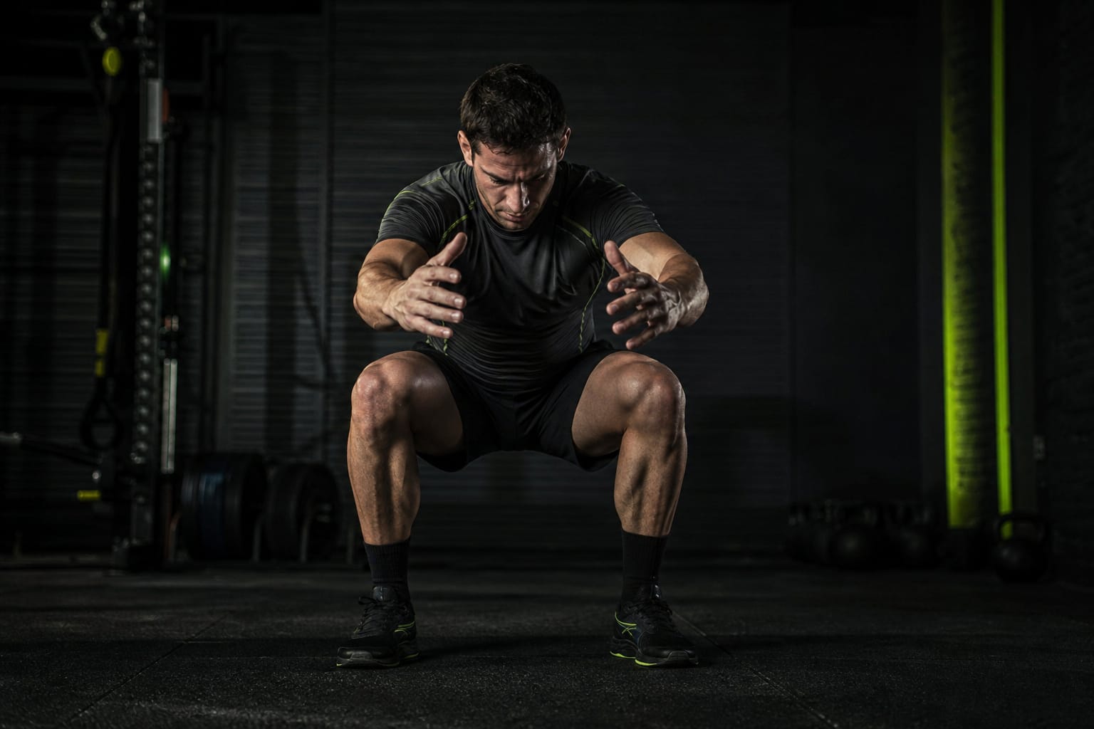 Athlete absorbing force on a controlled landing — illustrative Dark Kinetics atmosphere, not a real client or testimonial
