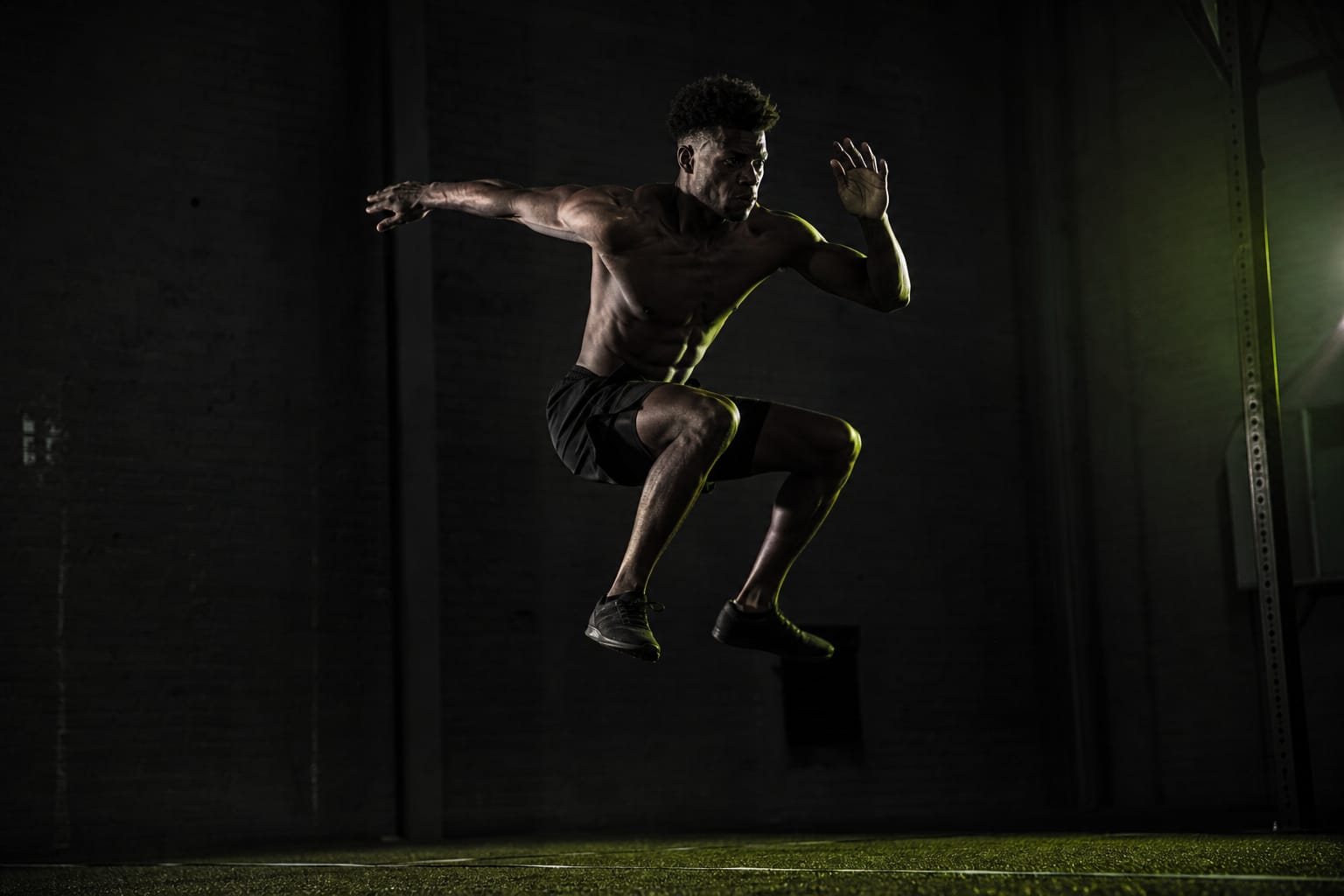Athlete expressing athletic power in a jump — illustrative Dark Kinetics atmosphere, not a real client or testimonial
